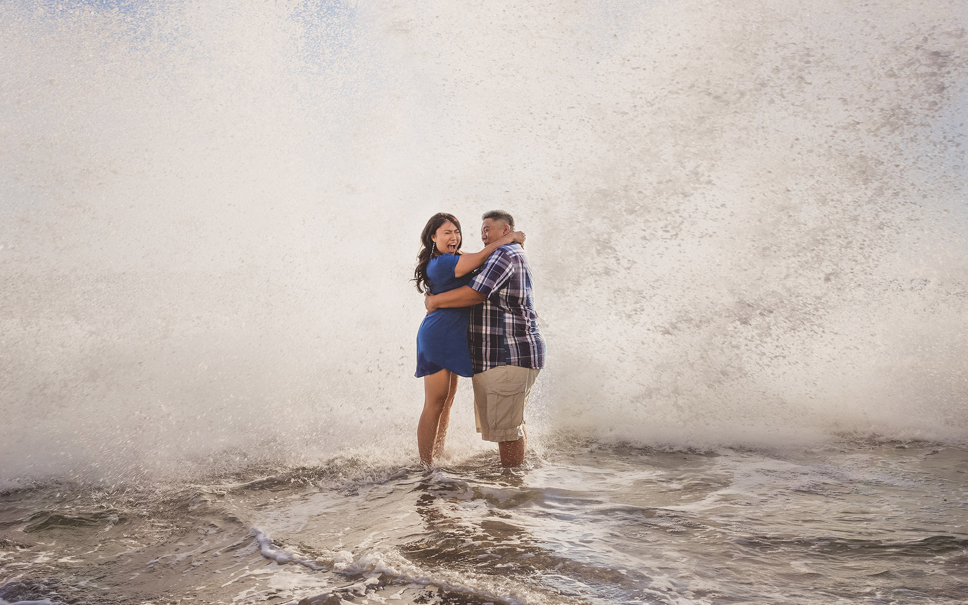 couple standing surpised ocean wave